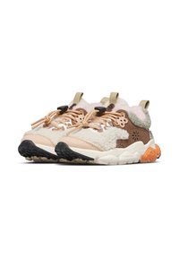 Sneaker senza lacci con una combinazione di texture crema, beige e marrone, con una parte superiore soffice, suola in gomma nera e arancione e accenti di logo discreti.