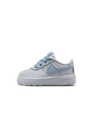 White leather Nike sneaker with light blue swoosh and laces, low-top design, and textured sole on white background.