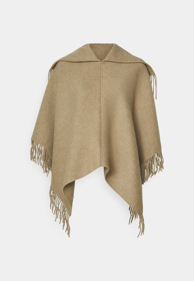 Poncho beige avec un large col, présentant une texture lisse et de longs franges à l'ourlet. Design simple et polyvalent, idéal pour la superposition.