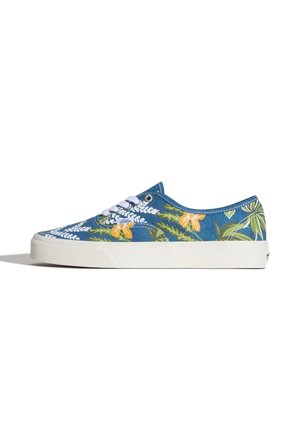 Baskets basses Vans en tissu bleu, semelle blanche, lacets blancs et imprimé floral tropical jaune et vert sur les côtés.