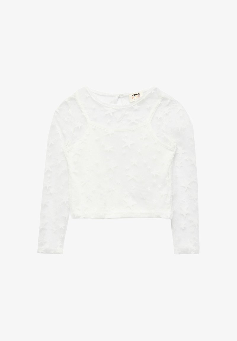 Haut blanc à manches longues pour fille avec superposition en mesh présentant des motifs d'étoiles en relief et un col rond, étiqueté Koton Kids.