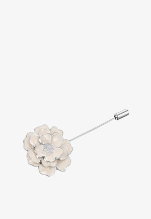 Broszka w kształcie kwiatu z białą emalią i łodygą w srebrnym odcieniu. Płatki mają faliste krawędzie oraz teksturowane centrum.