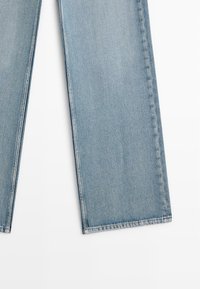 Svetle modré džíny z denimu se střihovým designem rovného nohavice, s čistým zakončením bez opotřebení a standardními detaily zakončení.