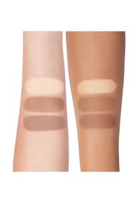 Palette montrant trois échantillons de teintes de fond de teint sur une peau claire et trois sur une peau plus foncée. Différentes nuances allant du beige clair au brun foncé.