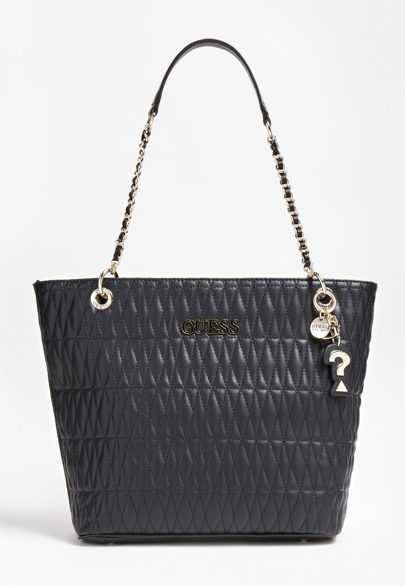 Svart vadderad axelväska med kedja och läderrem, guldig GUESS-logotyp och hängande charms inklusive ett frågetecken och en rund tag.