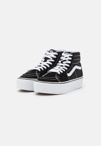 Zwarte suède hoge sneakers met witte veters en stiksels, met een wit golfontwerp en een platform witte zool.