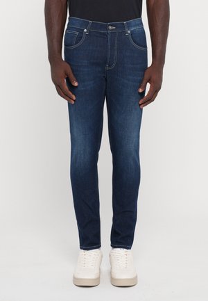 JeANS in denim blu scuro con vestibilità slim, dotati di cinque tasche, cuciture gialle e un bottone con chiusura in metallo.