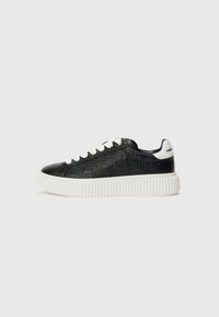Fekete bőr sneaker dombornyomott mintával, fehér textúrájú talppal és fehér fűzőkkel. Márkanevének kiemelése fehér színben a sarokon.