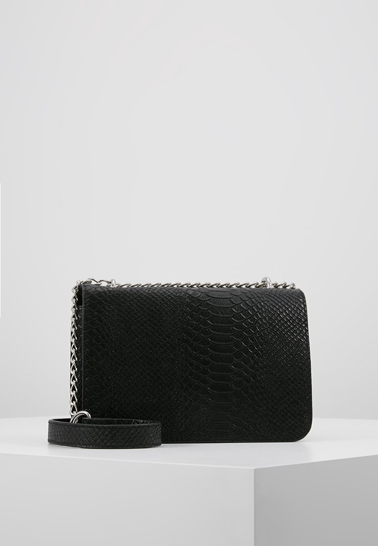 Borsa nera con esterno testurizzato a motivo rettile. Presenta una tracolla a catena argentata e un design piatto per un trasporto facile.