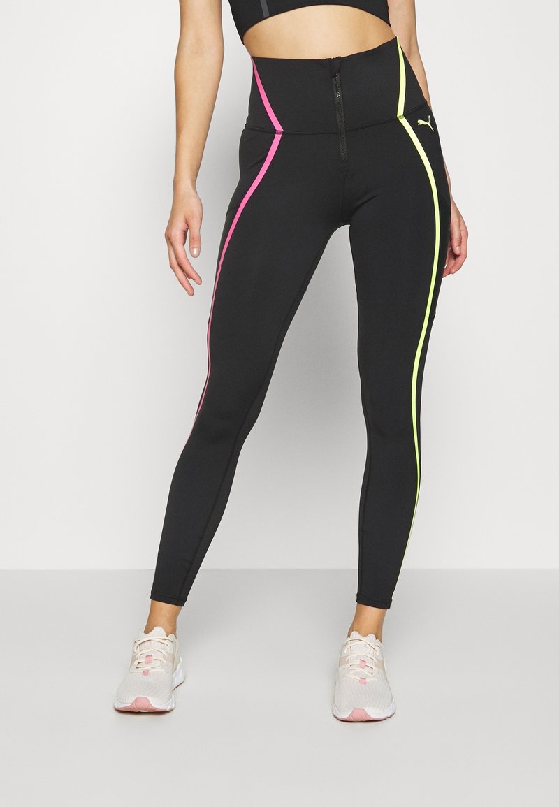 Czarne legginsy wysokie w pasie z różowymi i neonowymi żółtymi paskami po bokach. Materiał to elastyczna tkanina; posiada zamek błyskawiczny z przodu. Akcentowane logo Puma.
