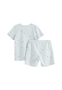 Pigiama corto in cotone azzurro chiaro con maniche corte, caratterizzato da un motivo di piccole barche in blu navy e rosso; include pantaloni short abbinati con vita elastica.