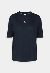 T-shirt à manches courtes bleu marine en tissu doux, avec un logo Jordan blanc centré sur la poitrine et un col rond.