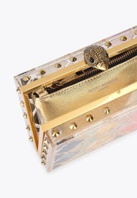Clutch in acrilico trasparente con dettagli dorati, caratterizzato da una pochette con cerniera dorata testurizzata, bordi impreziositi da borchie e una chiusura ornata a forma di uccello.