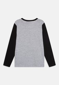 Camisa de mangas longas com corpo cinza e mangas pretas. Tecido suave com decote redondo e design de cores contrastantes nas mangas.