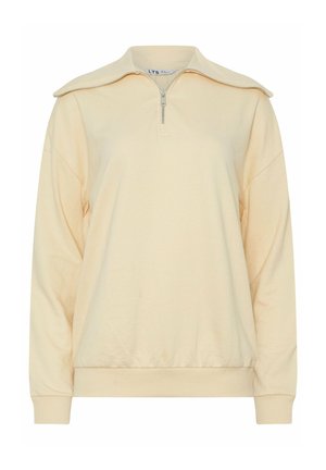 Beige pullover met lange mouwen, een halve rits bij de kraag en elastische boorden bij de mouwen en taille, afgebeeld tegen een effen witte achtergrond.