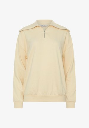 Pullover beige a maniche lunghe con colletto a zip a metà e polsini ed elastico in vita, mostrato su uno sfondo bianco semplice.