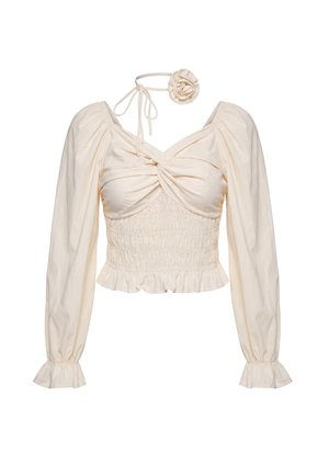 Cremige, langärmelige, kurz geschnittene Bluse mit geraffter Brust, gesmokter Taille, Rüschensaum und abnehmbarer Halsbinde mit Stoffblume.