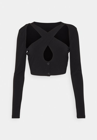 Top corto negro de manga larga en tejido suave, con un diseño cruzado que presenta un detalle de ojal y cierre de botón en la parte delantera.