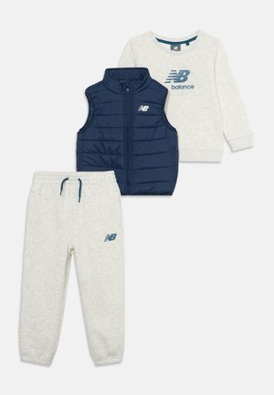 Ensemble de vêtements pour enfants comprenant un sweat-shirt gris clair à manches longues, un pantalon de jogging assorti et une veste matelassée sans manches bleu marine, tous avec les logos New Balance.