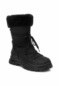 Botas de invierno negras con puño forrado de piel, parte superior de nailon, cierre con cordones en la parte frontal y suela de goma resistente para mayor agarre y tracción.
