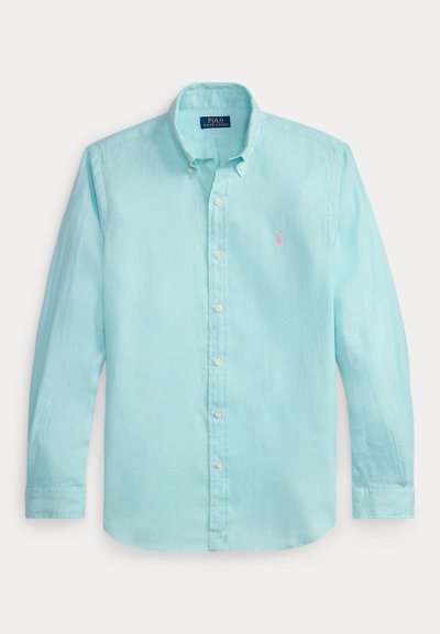 Camisa de manga larga azul claro con botones, hecha de lino. Cuenta con un cuello clásico, botones blancos y un pequeño logo rosa en el pecho.