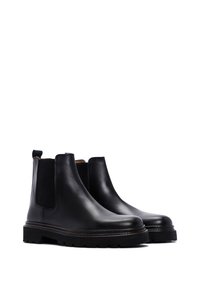 Zwarte leren Chelsea boots met elastische zijpanelen en een trekband, met een gestructureerde rubberen zool en een slanke, rond afgewerkte neus.
