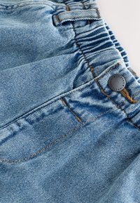 Hele sinine teksakangas kogutud vöökohaga, millel on tume metallnupp ja nähtavad õmbluse detailid. Siidine tekstuur, vabaaja disain.