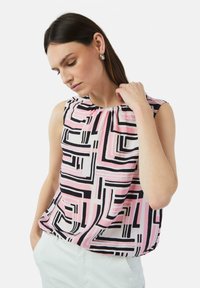 Mouwloze blouse met een geometrisch patroon in roze, zwart en wit. Zachte stof met geplooide halslijn.