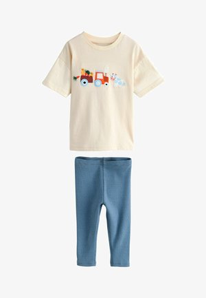 Camicia beige a maniche corte con trattore rosso ricamato, pulcini e mucca, abbinata a pantaloni aderenti a righe blu per bambino.
