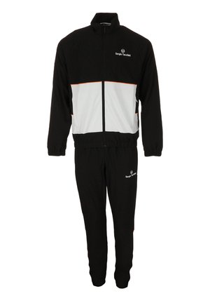 Zwart-wit trainingspak gemaakt van zachte stof. Het jack heeft een hoge kraag, een ritssluiting aan de voorkant en oranje accentstrepen. De broek is elastisch bij de enkels.