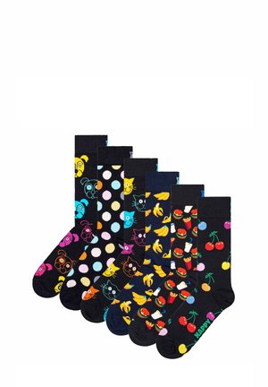 Set mit sieben schwarzen Socken, die bunte Muster zeigen: Tiere, Punkte, Bananen, Lebensmittel und Kirschen mit dem Text "HAPPY" in Grün.