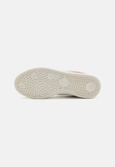Hvit sneaker med såle i teksturert gummi, med sirkulære og lineære mønster. Utsmykket med en subtil rosa detalj på overdelen.