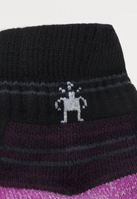 Pletené ponožky s čierno-fialovým pruhovaným dizajnom, so štruktúrovaným vzorom a malým sivým logom na vrchu.