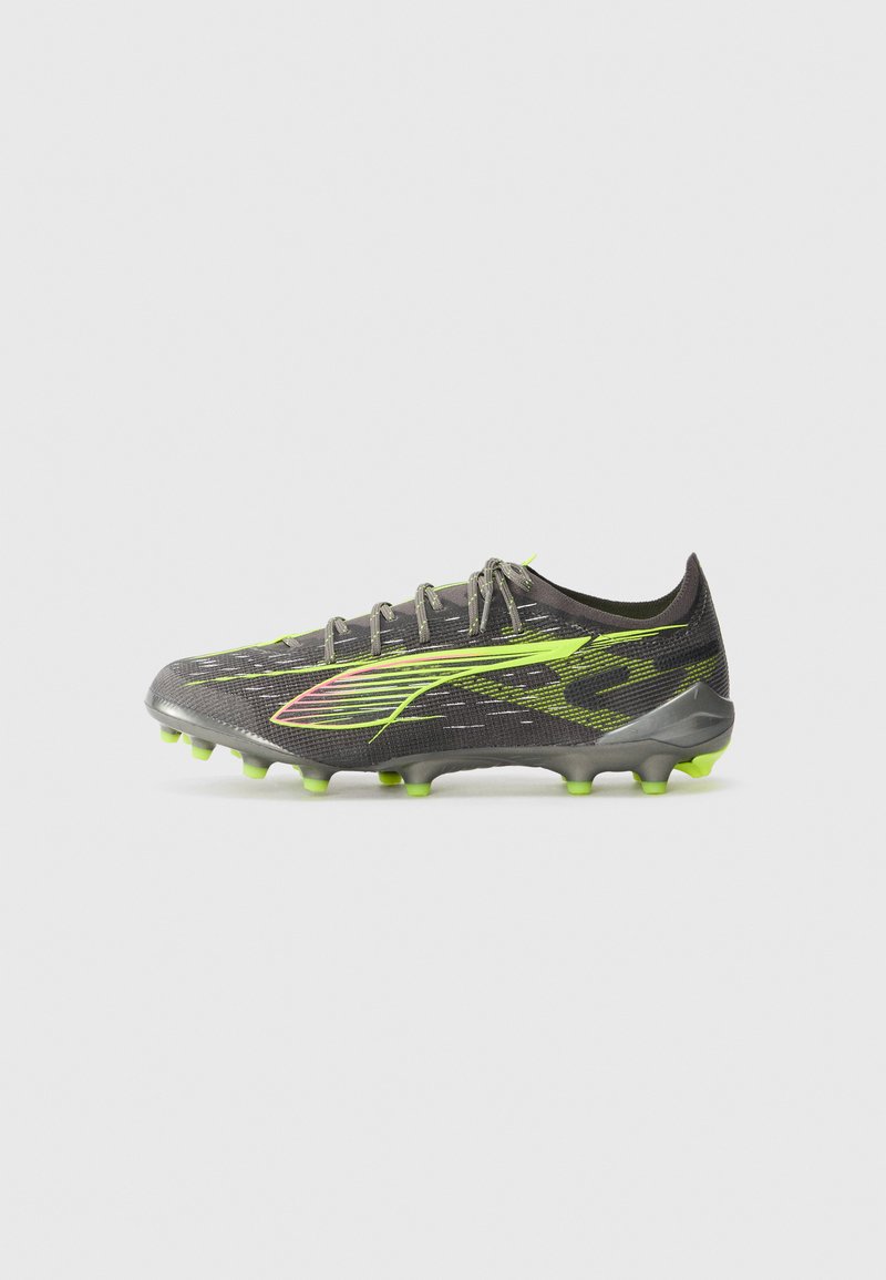 Scarpa da calcio nera e verde neon con tomaia sintetica testurizzata, design a profilo basso e tacchetti sagomati per la trazione su superfici erbose.