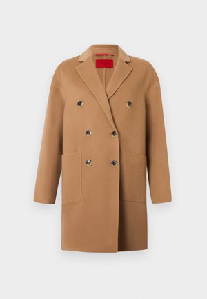Double-breasted coat in soft camel wool, featuring large front pockets, black buttons, and a notched lapel design.
