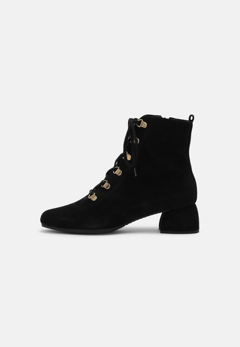 Bottine en daim noir avec toe arrondi, détails en métal doré et petit talon bloc. Caractérisée par un laçage avant et une languette de tirage à l'arrière.