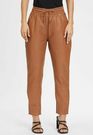 Bruine leren joggingsbroek met een elastische tailleband en trekkoord, voorzien van zijzakken en een tapered leg ontwerp.