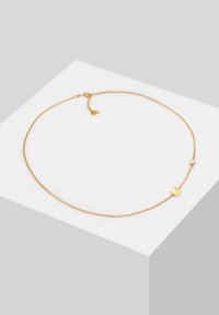 Gold chain necklace featuring a small crescent moon charm and a clear gemstone accent, with a delicate link design and clasp closure.