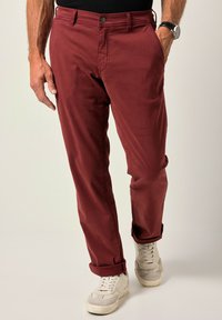 Bordové bavlněné kalhoty s rovný fit, přední kapsy a manžetami, kombinované se světlými teniskami. Hladký povrch, jednoduchý design.