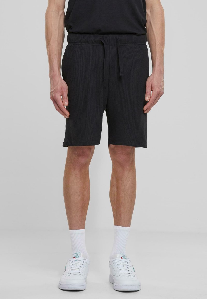 Shorts en coton noir avec une taille élastique et un cordon de serrage. Design simple avec une coupe droite, atteignant la mi-cuisse.