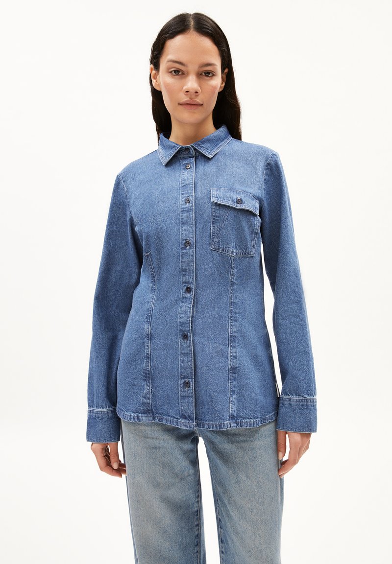 Hellblaue Denim-Hemd mit Knopfverschluss, Kragen und einer einzelnen Brusttasche. Es hat lange Ärmel und eine lockere Passform.