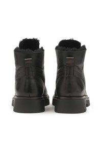 Botas de cuero negras hasta el tobillo con un suave forro de piel de borrego negro, suelas de goma planas y un diseño elegante. Presenta una pequeña pestaña trasera para ponerlas y quitarlas fácilmente.