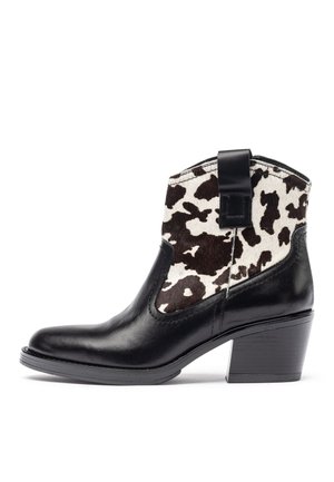 Botín de tobillo de cuero negro que presenta un prominente upper de textil con patrón de piel de vaca, con pestaña de agarre y tacón apilado.