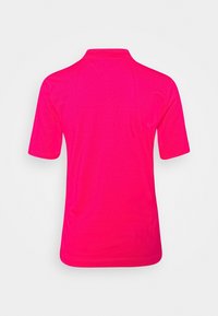 Polo à manches courtes de couleur rose vif, avec un col classique et une texture lisse. Sans motifs ni accents visibles.
