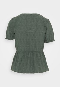 Grünes, kurzärmeliges Oberteil mit Peplum-Saum, aus strukturiertem Stoff gefertigt, der bestickte Lochmuster aufweist und einen runden Halsausschnitt hat.