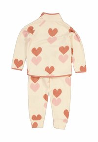 Fleece pyjamaset med en krämfärgad bas och rosa och bruna hjärtformade mönster, långa ärmar och mudd på både byxor och tröja.