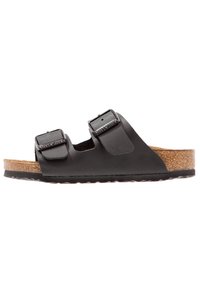 Svart lädersandal med två justerbara remmar och silverdetaljer. Formad korkfotbädd, gummiyttersula och platt design.