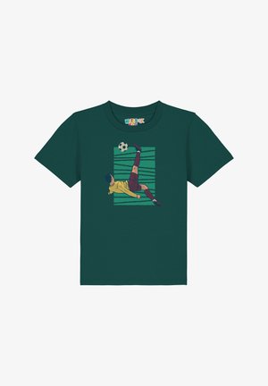Groene t-shirt met een afbeelding van een voetballer in geel en bordeauxrood, die een zwart-witte bal trapt tegen een gestreepte achtergrond.