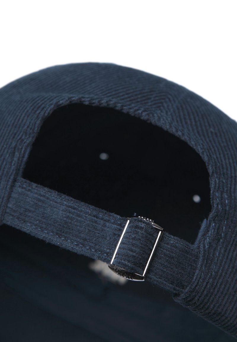 Navy blue corduroy baseball cap featuring a metal adjuster, an embroidered interior, and a curved brim. The texture is ribbed.