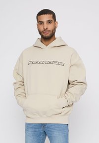 Beige hoodie med et stort "PEGAJOR" grafisk tryk i sort, med snoretræk i hætten og lommes front. Blødt stof og afslappet pasform.